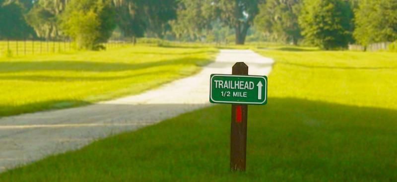 trailhead sign and paved trail