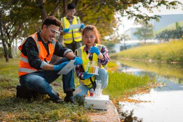 students and teacher in life vests testing water