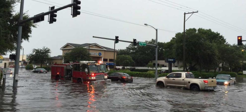 Urban flooded intersection with vehicles in deep water