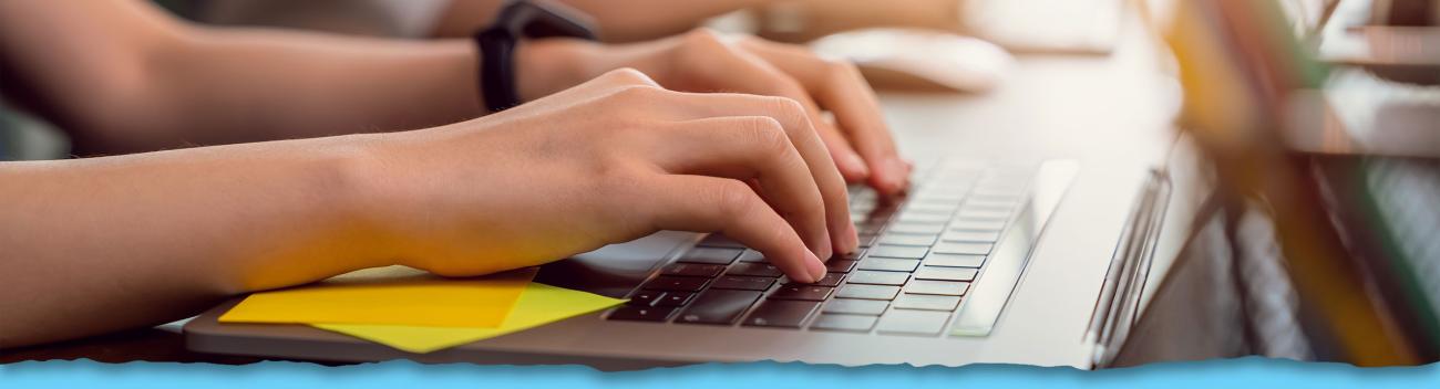 Woman's hands typing on laptop