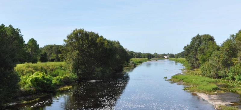 channel of water with vegetation and trees along the sides