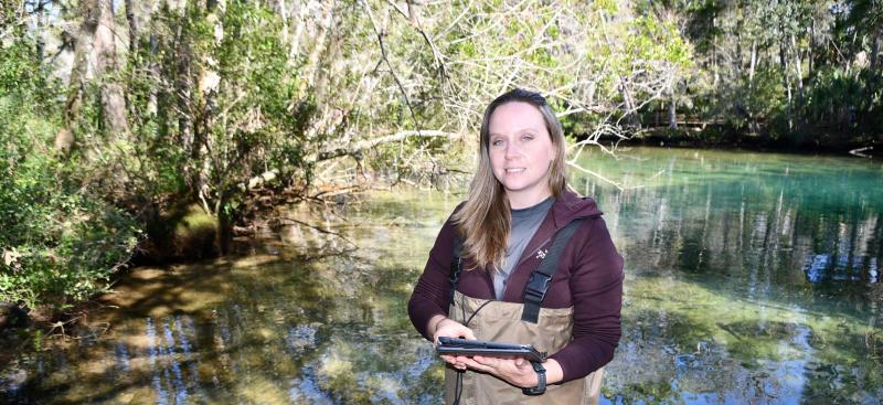 District technician in stream collecting water data