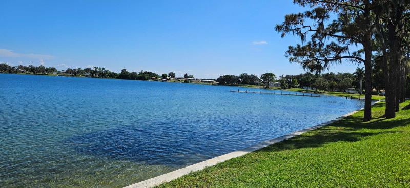 Grassy bank beside a blue lake under a sunny blue sky