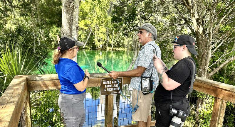 News crew interviewing District staff in the field