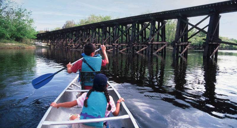 Canoeing on Peace River near trestle bridge