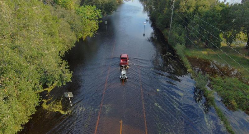Truck driving down a flooded road after Hurricane Milton 2024