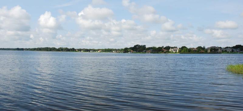Panorama of Florida lake with homes on tree-lined far shore