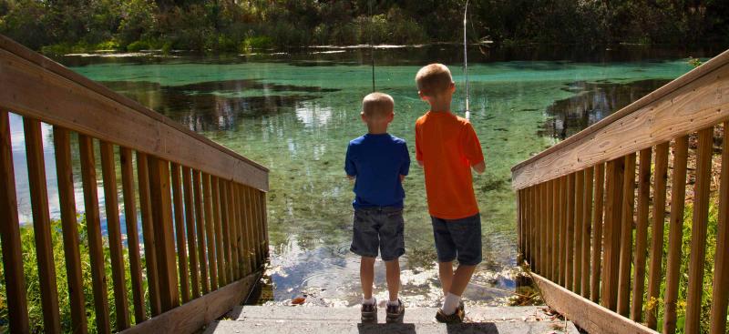 two boys fishing from river shore