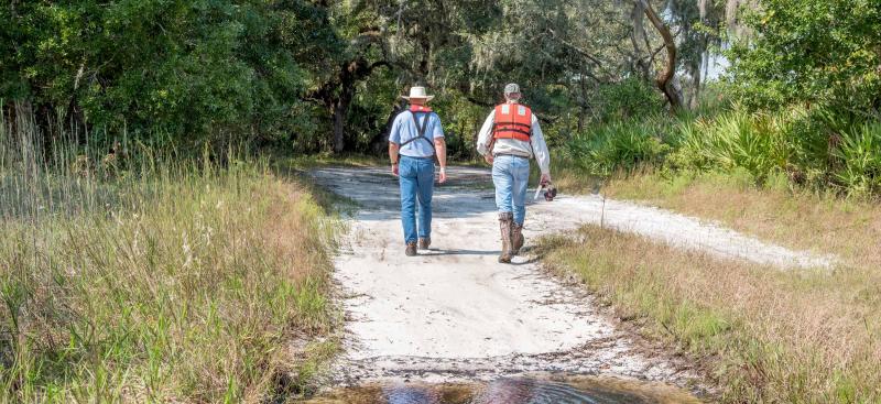 District staff walking on sandy trail near Withlacoochee River