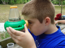 student looking through magnification glass