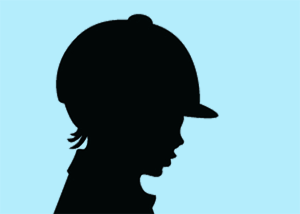 Silhouette of young rider wearing an equestrian helmet