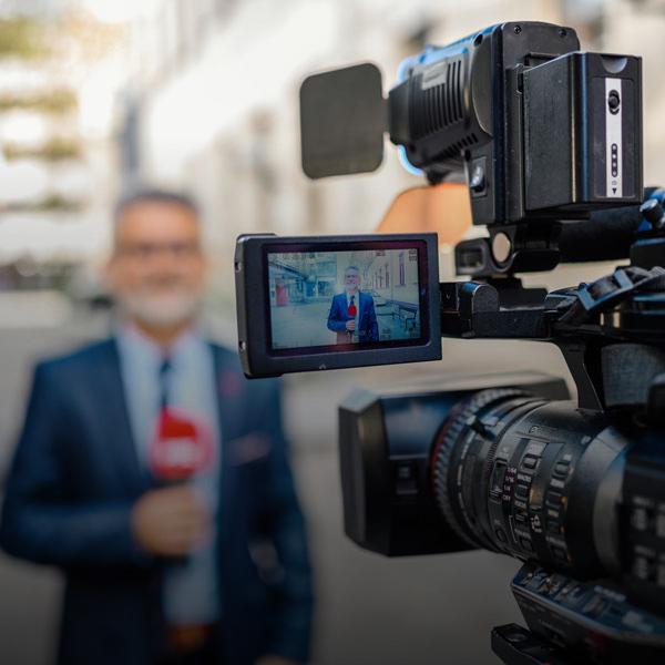 News reporter on location with video camera recording