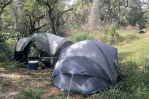 Two tents in wooded campsite near the Peace River