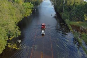 Truck driving down a flooded road after Hurricane Milton 2024