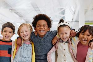 happy kigs in classroom with arms around each other