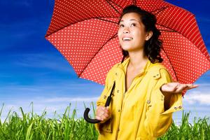 Girl in yellow raincoat holding red umbrella