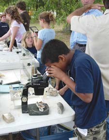 student looking through microscope 