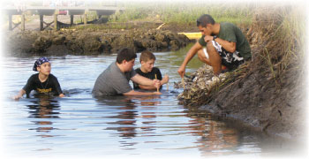 Scouts placing oyster culch bags along shoreline